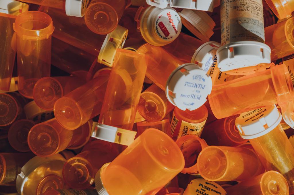 Pile of empty plastic medicine bottles.
